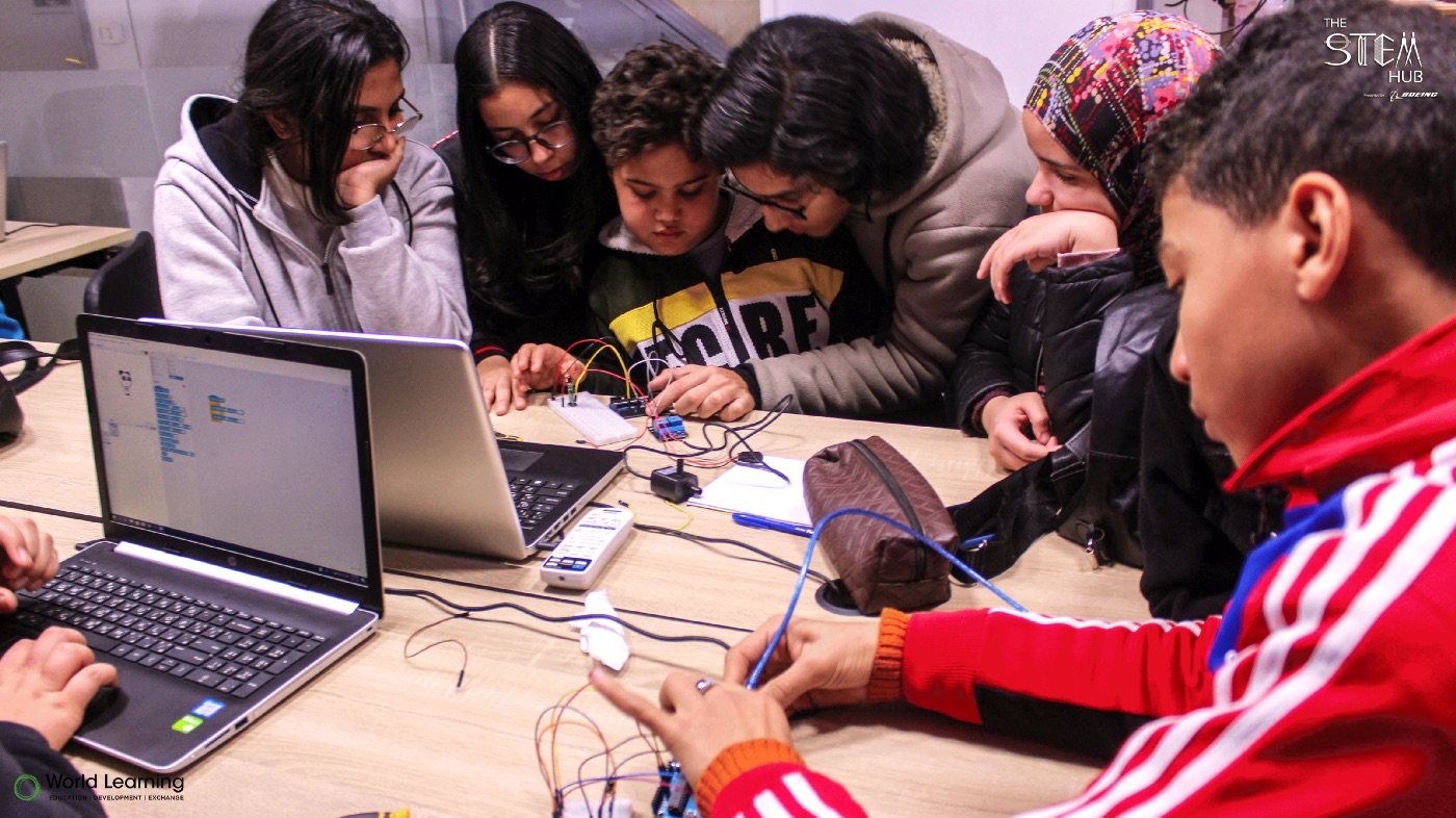 Students building a circuit on a breadboard during a workshop.